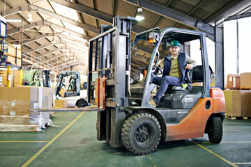 Driver, warehouse and man with forklift on site working, loading on dock with Industrial moving vehicle. Transporting, shipping inventory with safety hardhat for delivery, labor worker for company © peopleimages.com