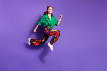 Full length active pretty girl wear print trousers green shirt flying on season sale to empty space isolated on violet color background