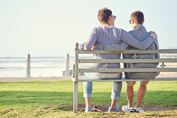Couple, park and bench for gay male people, ocean and promenade in nature. LGBT, love and hug or affection for married queer relationship, partner and honeymoon on holiday for bonding or relax