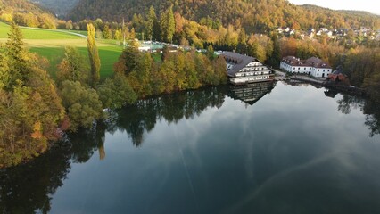 Aerial view of Lake Crnava surrounded by greenery on a sunny day in Slovenia - obrazy, fototapety, plakaty
