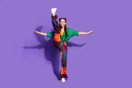 Full length photo flexy girl wear print trousers vintage shirt dancing impressively raising up feet isolated on violet color background