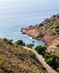 Scenic beach landscape featuring a rocky shoreline stretching out towards the clear blue waters