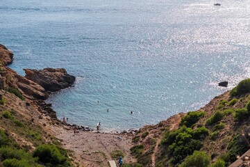Scenic beach landscape featuring a rocky shoreline stretching out towards the clear blue waters