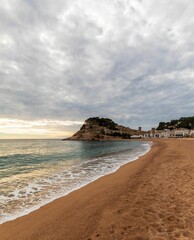 Old castle on a rocky hill on the tropical beach with white sands in Tossa De Mar