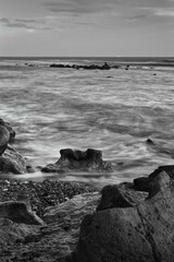 Scenic view of the beach from rocks near the ocean with waves - obrazy, fototapety, plakaty