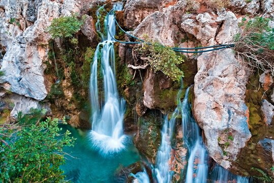 Majestic Big waterfall cascading down a rugged cliff in Kourtaliotiko Gorge, Foinikas, Crete, Greece