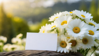 Obraz premium Mock up of white blank paper card and beautiful chamomile flowers for holiday greetings. Spring bouquet.