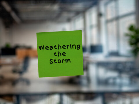 Post note on glass with 'Weathering the Storm'.