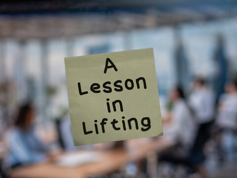 Post note on glass with 'A Lesson in Lifting'.