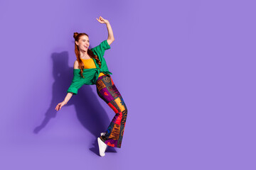 Full length photo of overjoyed girl wear print trousers stand on tiptoes look at discount empty...