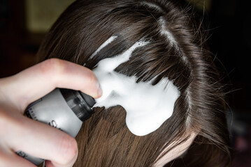 Applying foam for hair styling.