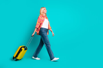 Photo of adorable cute positive retired woman wear checkered stylish clothes travel tour empty space isolated on cyan color background