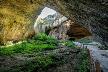 Stunning view of Devetashka Cave in Bulgaria, featuring rocky walls and natural holes.