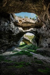 Stunning view of Devetashka Cave in Bulgaria, featuring rocky walls and natural holes.