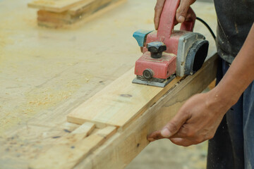 Close up of sanding a wood with orbital sander at workshop