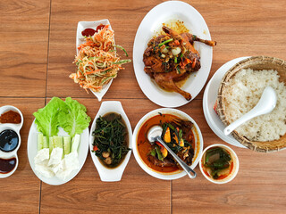 background of a diverse food menu from spiced fried chicken, stir-fried water spinach, fish curry, vegetable bakwan and fresh vegetables at the Kampong Laok restaurant