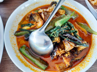 background of smoked fish coconut milk curry with vegetable and tomato toppings