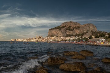 Scenic view of the coastline featuring cliffs and buildings in Cefalu, Italy