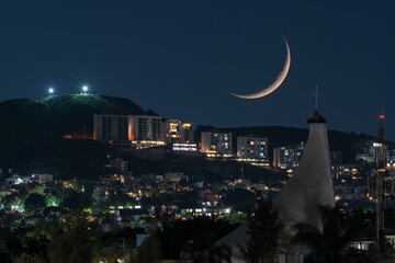 Waning Crescent Moon setting over urban cityscape after
