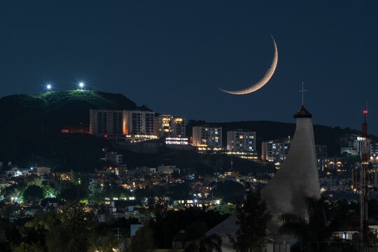 Waning Crescent Moon setting over urban cityscape after
