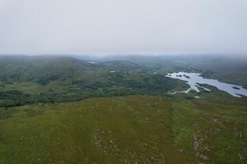 Aerial view of a picturesque landscape with a lake and lush green grassy areas in Ireland, Kerry