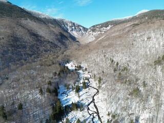 Aerial view of The Iconic Notch road leading through the Green Mountains of Vermont mid-winter.