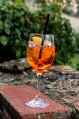 Cold, iced summery orange aperitif drink in a wine glass