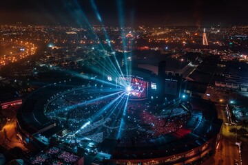 Fototapeta na wymiar A drone captures an aerial view of a brightly lit stadium at night. The lights illuminate the field and stands