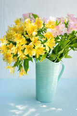 delicate bouquet of alstroemerias in a blue vase - 770745485
