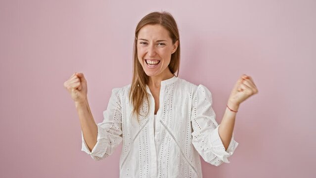 Beautiful young woman, full of joy, standing over an isolated pink background, screaming with a cheerful happy smile. celebrating her victory with a confident winner's expression, truly a triumph.