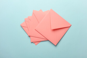 Pink square paper envelopes on blue pastel background