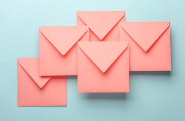 Pink square paper envelopes floating on blue pastel background
