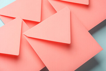 Pink square paper envelopes floating on blue pastel background