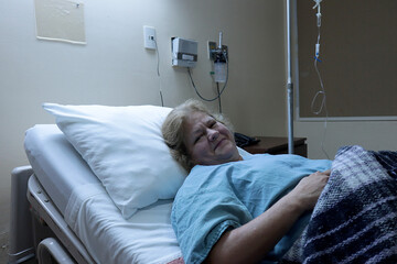 Mujer mayor en camilla en un cuarto de hospital sonriendo