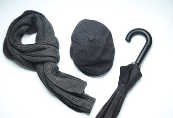 Vintage woolen English eight-piece cap with scarf and umbrella on a white background. Gentleman's accessories