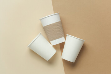 Disposable cardboard cups for hot drinks on a beige background