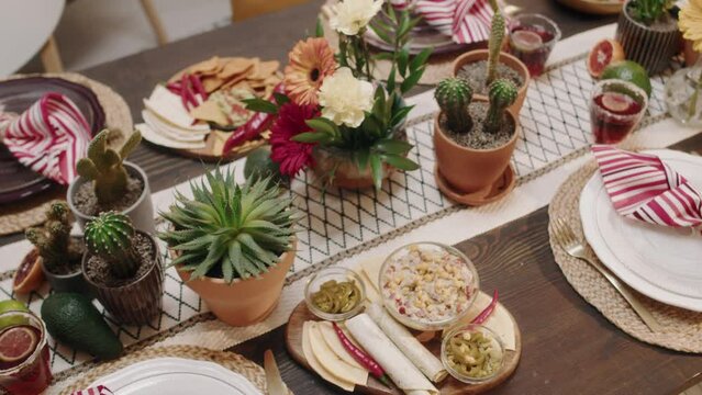 Top pan no people shot of beautiful festive table with traditional Mexican cuisine food - chalupa, fajita, burrito, nachos, tacos, guacamole, salsa, chilli, prepared for Cinco de Mayo celebrationTop p