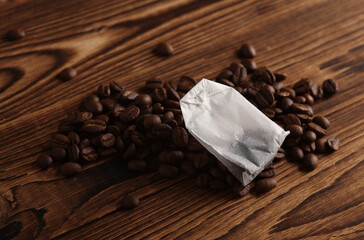 Tea bag and coffee beans on wooden background