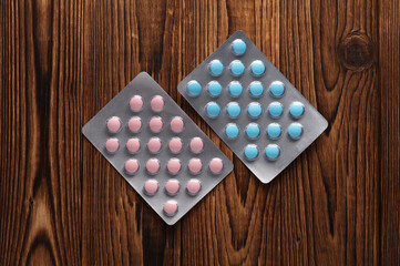 Blisters of tablets on a wooden table close-up
