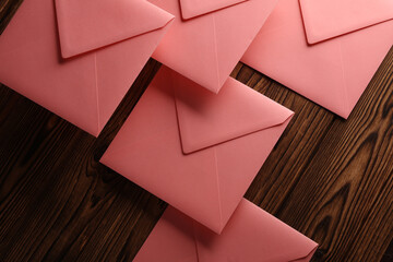 Pink square paper envelopes on wooden background