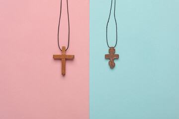 Wooden Christian crosses on a string, pink blue background
