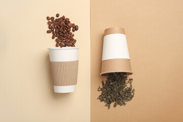 Cardboard cups for hot drinks with coffee beans and green tea on a beige background