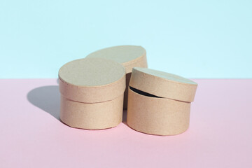 Round craft cardboard boxes for product on blue pink pastel background