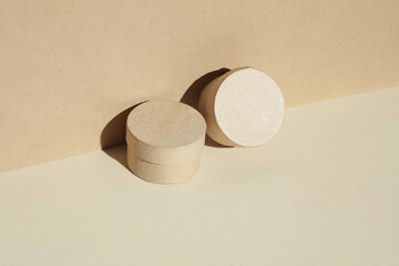 Round craft cardboard boxes for product on beige background