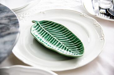 a porcelain green decorative leaf as a coaster for Easter