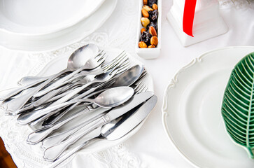 white decorations with forks spoons and forks with white plates and stone board