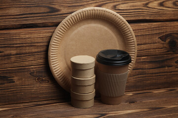 Disposable eco consumables for cafe and delivery on wooden background - obrazy, fototapety, plakaty