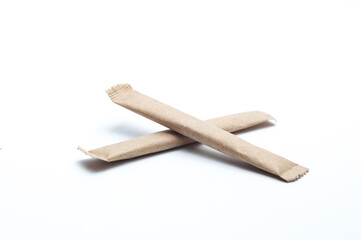 Disposable paper craft sticks with sugar or coffee on white background
