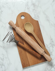 Wooden kitchen utensils on a marble background. Top view