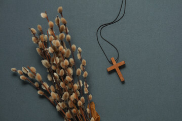 Willow twigs and Christian cross on a string, dar k gray background